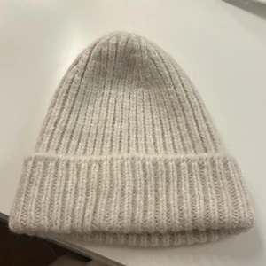 Off-white mössa - Oanvänd mössa från H&M. Den kliar inte och är helt ny. Säljer eftersom jag inte tycker färgen passar mig