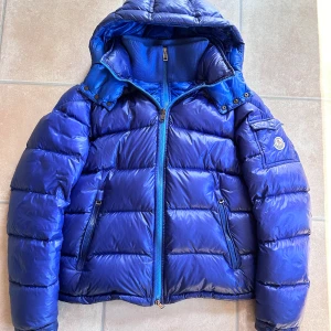 Moncler Zin - Blå/lila Moncler Zin jacka i väldigt fint skick, finns en mini reva framtill som knappt syns. Bilder på tags osv löses självklart vid fråga, får bara plats med 5 bilder 🙃 Size 2 passar S/M, nypris 14.500kr mitt pris 6000 men tar emot rimliga bud! 