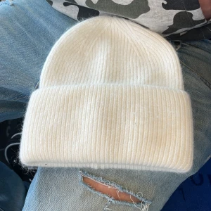 Mössa - Vit mössa i mjukt skönt material. Passar alla storlekar och är perfekt nu till vintern.