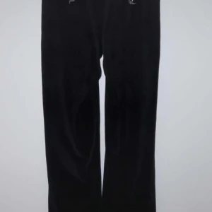 Svarta mjukisbyxor med textdetalj - Säljer ett par svarta mjukisbyxor i skönt material. De har en cool textdetalj 'ANGELIC' i glittriga stenar på baksidan. Perfekta för en avslappnad dag hemma eller en chill dag ute. Byxorna har en loose passform och är superbekväma. Passar perfekt till höst och vinter!