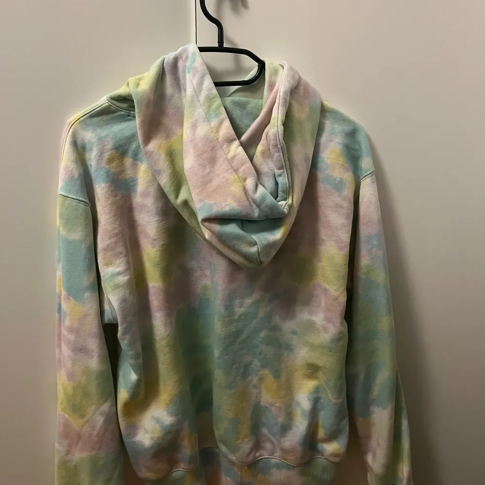 Säljer en hoodie från Champion i en färgglad tie-dye stil. Den har en stor ficka fram och justerbar huva med snören. Inköpt för 2 år sen för 900kr. Katt finns i hemmet men den är tvättad och rollad innan den skickas. Hoodies.