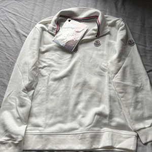 Vit Moncler Tröja  - Ett helt ny Moncler tröja/kofta som är oanvänd. Jätte bra skick 10/10 ✅, skickar den på samma dag du köper