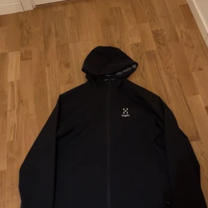 Haglöfs jacka  - Varan är i väldigt bra skicka förutom lilla hålet under höger ficka, sista bild. Bara använts en höstsäsong. Storlek M men passar L. Köpt på Zalando för ungefär 2300 men säljs billigt pågrund av hålet.  Pris kan fortfarande diskuteras vid snabb affär.