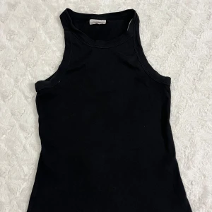 Svart ribbad linnetopp - Säljer en svart ribbad linnetopp från Gina tricot i storlek M. Perfekt för sommardagar eller som ett basplagg i garderoben. Toppen är i bra skick och har en tight passform som framhäver figuren. Superbekväm och lätt att matcha med olika outfits!