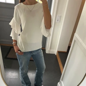 Vit trekvartsärmad blus  - Vit volangtopp från Dorothy Perkins i storlek 38, passar S och M. Fint skick.