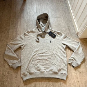 Polo Ralph lauren hoodie - En sprillans ny grå polo Ralph lauren hoodie, inte använd. (Lapp syns på bilden) Är storlek M men passar även till dig som bär S!!! Skriv vid frågor och funderingar! Nypris:2199kr Mitt pris:1200 Priset är inte hugget i sten!!!😄