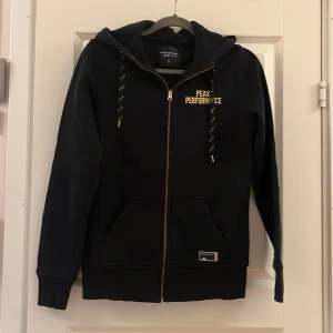 Hoodie med zip - Svart hoodie från Peak Performance strl M