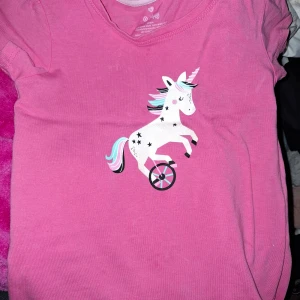 Enhörning rosa -  Topp med glittrig enhörning på. 😊🩷 storlek 5år. Finns nån färgskiftning som jag inte har fläckbehandlat, den har enbart legat i garderob.