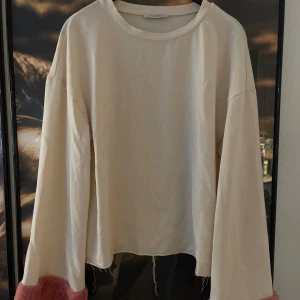 Vit tröja från Zara  - Säljer en vit tröja från ZaraDen har långa ärmar och en croppad passform med en unik rosa detalj vid ärmsluten. Perfekt för en avslappnad stil eller att klä upp med accessoarer. Superbekväm och stilren!