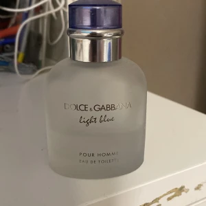 Dolce & Gabbana Light Blue Pour Homme Eau de Toilette - Säljer en fräsch och maskulin parfym från Dolce & Gabbana, Light Blue Pour Homme. Flaskan är frostad med en stilren design och har en blå kork. Perfekt för den som vill ha en lätt och uppfriskande doft. Du kan se hur mycket det är kvar på bilden. Pris kan diskuteras