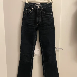 Mörkblå jeans från Zara - Snygga marinblå jeans från Zara med hög midja och klassisk femficksdesign. Jeansen har en rak passform och stängs med dragkedja och knapp. Perfekta för en stilren look.
