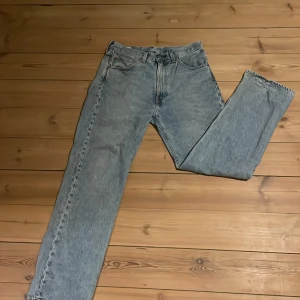 Levis w32 - Säljer ett par klassiska blå jeansbyxor med rak passform. De har en traditionell femficksdesign och en knappgylf. Perfekta för en avslappnad stil.