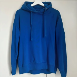 Blå hoodie - Säljer en blå hoodie med justerbar dragsko i huvan. 