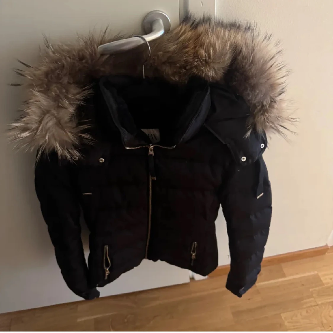 Svart dunjacka med pälsdetaljer