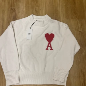 Ami Paris  - säljer en Ami Paris tröja i färgen vit med ett röd hjärta åt sidan. Den är i storlek S och har en jättebra passform. Tröjan är helt ny och har aldrig använts. Jag säljer den eftersom den var liten för mig. Priset på den kommer att vara 1400, men kan diskuteras vid snabb köp