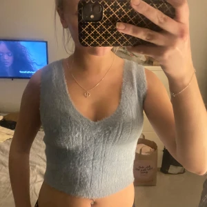 Ljusblå gosig topp - Säljer en mysig ljusblå ärmlös topp från FB Sister. Toppen har en v-ringad design och är tillverkad i ett fluffigt material som ger en skön känsla. Perfekt för en avslappnad stil🩵💙💙