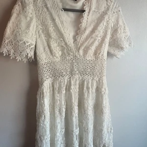 Vit spetsklänning från Gina Tricot - Säljer en vacker vit spetsklänning från Gina Tricot med korta ärmar och v-ringning. Perfekt till sommaren eller studenten!🌸Super fin, säljs inte längre.