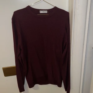 Vinröd tröja från Mango  - Säljer en stilren vinröd tröja från Mango. Tröjan har en enkel design med långa ärmar och rund halsringning. Perfekt för en avslappnad och snygg look. Passar bra till både jeans och chinos.