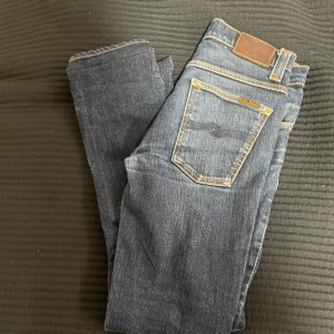Mörkblå jeans från Nudie Jeans - Snygga mörkblå jeans från Nudie Jeans i modellen Grim Tim. Storlek 30/32, slim fit. 
