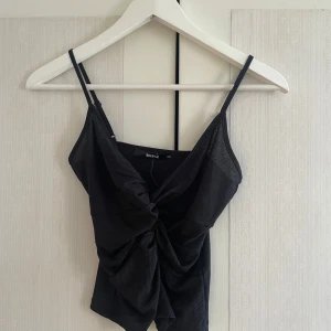 Svart topp - Snygg svart topp med smala axelband och knytdetalj framtill🫶🏼
