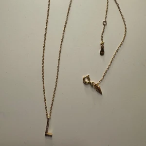 Guldhalsband med bokstavsberlock - Elegant guldhalsband med en bokstavsberlock 'L'. Kedjan är tunn, säljer pga ingen användning längre💕 köpte kedjan och berlocken för sig på glitter så dom fick sätta ihop den💕