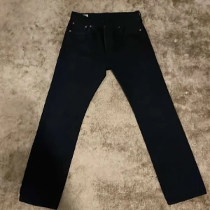 Svarta Levis 501 jeans - Klassiska svarta Levis 501 jeans i storlek W30 L 30. Dessa jeans har en rak passform och är tillverkade i slitstarkt denim. Perfekta för en stilren look. Priset är ej hugget i sten, slide dm för intresse👍🏽👍🏽
