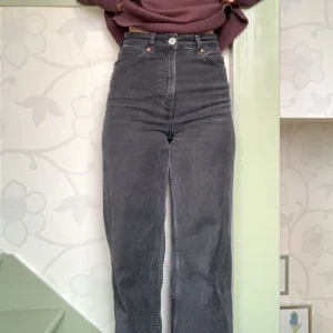 Mörkgrå högmidjade jeans - Snygga grå jeans med hög midja och en rak passform. Perfekta för en avslappnad stil. De har klassiska fem fickor och en knappgylf. Passar bra till både sneakers och boots.