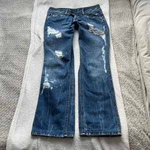 Pepe jeans  - Snygga jeans från Pepe Jeans med coola slitningar och en bootcut-stil. De har en låg midja och klassisk femficksdesign. Tvärs över midjan är de 37cm & innerbenslängden är 78cm