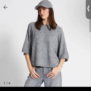 Grå stickad tröja - Säljer en stilren grå stickad tröja med trekvartsärm. Perfekt för en avslappnad look. Tröjan har en lös passform och är gjord i ett mjukt material som känns skönt mot huden.