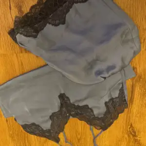 Säljer blått satinlinne tillsammans med shortsen  från H&M med fina svarta spetsdetaljer längs kanterna. Oanvänt eftersom de inte riktigt är min smak riktigt💕