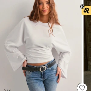 Vit långärmad topp med vida ärmar från Nelly  - Helt ny och oanvänd med prislapp kvar(hann ej skicka tillbaka💕 Säljer en stilren vit topp med långa vida ärmar och en tight passform. Perfekt för en trendig look. Passar bra till både jeans och kjol.