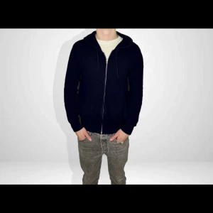 Mörkblå 100% kashmir hoodie - Säljer en stilren mörkblå hoodie i mjuk kashmir. Tröjan har en dragkedja framtill och långa ärmar. Nypris 900kr