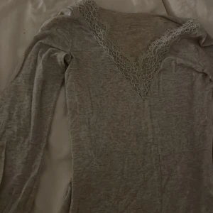 Beige  långärmad topp med spetsdetaljer intimissmi  - Säljer en elegant grå långärmad topp från Intimissimi med vacker spetsdetalj vid halsringningen och ärmsluten. Perfekt för en stilren look. Passar bra till både jeans och kjol.❤️både den vin röda och beiga säljs för dyrt för att de är materialet kashmir. 🥰