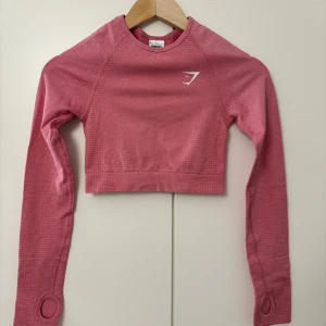 Rosa träningströja från Gymshark - Fin rosa croppad träningströja från Gymshark. Endast använd ett fåtal gånger, fintskick. Den är i storlek xs💕
