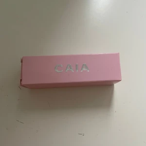 Läppbalm Cocoa Couture från CAIA - Snyggt lip balm i nyansen Cocoa Couture från CAIA. Kommer i en stilren rosa hylsa med silverdetaljer. Perfekt för att ge dina läppar en glansig snygg färg ps oanvänd 💓