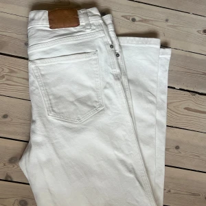 Jeanerica off white RM006 - Snygga vita jeansbyxor med klassisk femficksdesign och knappgylf. Perfekta för en stilren look. Gott skick, någon mindre fläck nedtill mot byxavslutet. Storlek 30/32. Se mina övriga annonser för fler grymma plagg! 