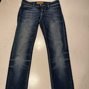 Blå jeans från Jacob Cohën i storlek W28/L30 - W28/L30.Snygga blå jeans från Jacob Cohën med klassisk femficksdesign och subtila slitningar för en trendig look. Perfekta för en avslappnad stil med en touch av elegans. Nypris 4000 men jag säljer dom för 1299. Dom är aldrig använda men ingen etikett. Priset är prutbart.