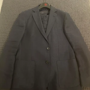 Mörkblå kostym set från dressman - Snygg mörkblå kostym set från Dressman. Perfekt för formella tillfällen med en klassisk passform och två knappar framtill. Tillverkad i ett elegant material som ger en stilren look. Kostymbyxor och kavaj ingår. Hela kostym settet har använts 1 gång. Kom DM om ni bara är intresserad i en av plaggen istället för båda. Pris kan självklart diskuteras💫