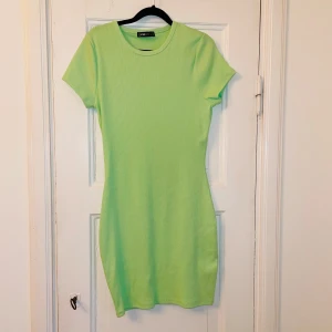 Grön ribbad klänning  - Oanvänd tyvärr är inga lappar kvar. Snygg grön ribbad klänning. Klänningen har en tight passform och korta ärmar, perfekt för en somrig look. Den är tillverkad i ett mjukt och bekvämt material som gör den skön att bära hela dagen. 