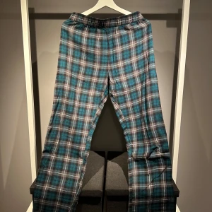 Rutiga pyjamasbyxor - Snygga och bekväma rutiga pyjamasbyxor med elastisk midja. Perfekta för en avslappnad stil. Skick 9/10. Hör av er om ni har några frågor!