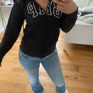 Svart hoodie  - Säljer en svart hoodie från GAP med dragkedja och stor logga på bröstet. Tröjan har långa ärmar och en bekväm passform. använd några gånger