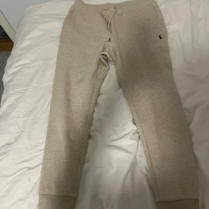 Beige mjukisbyxor från Ralph Lauren - Säljer ett par bekväma beige mjukisbyxor från Ralph Lauren. Byxorna har en broderad logotyp på sidan och snörning i midjan för justerbar passform. Perfekta för en avslappnad stil. Helt oanvänd 10/10 skick 
