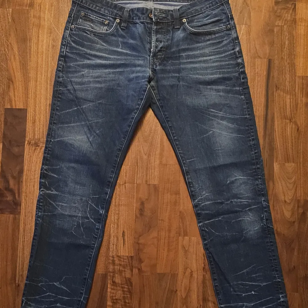 Snygga blå jeans från G-Star Raw, modell 3301. De har en low tapered passform och är tillverkade i slitstarkt denim. Perfekta för en avslappnad stil med coola detaljer som ger en trendig look.. Farkut & Housut.
