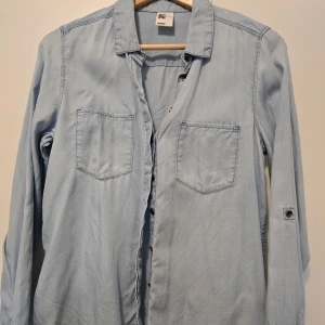 Ljusblå skjorta från H&M - Säljer en stilren ljusblå skjorta från H&M i mjukt material. Skjortan har långa ärmar och två bröstfickor 💙