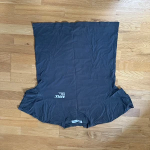 Mörkgrå t-shirt från Afex - Säljer en mörkgrå t-shirt från Afex. Den har en enkel design med korta ärmar och rund hals. Perfekt för en avslappnad stil.