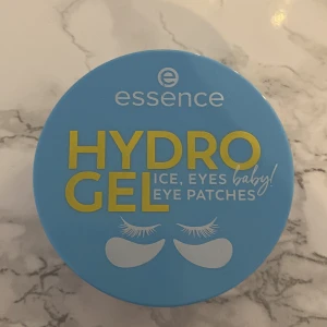 Essence Hydrogel Eye Patches - Essence Hydrogel Eye Patches är veganska och doftfria ögonmasker som kommer i en blå förpackning. Perfekta för att fräscha upp och återfukta huden under ögonen. Säljs utan original kartong så ingredienser finns på Lyko