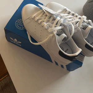 Vita Adidas Stan Smith sneakers - Snygga vita Adidas Stan Smith sneakers med klassisk design. Aldrig använda prislappen är kvar storlek 42 1/3 pris kan diskuteras som på allt vi säljer