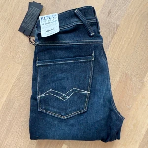 Nya Replay Hyperflex Anbass, 27/30 - Nya  mörkblå jeans från Replay i modellen Anbass. Slim passform och är tillverkade i Hyperflexmaterial för extra komfort och stretch. Nypris 1600 kr