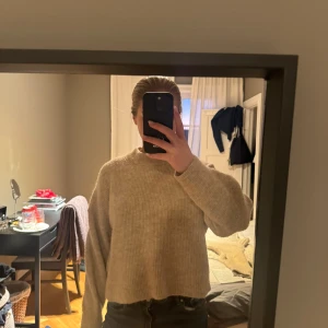 Beige stickad tröja - Säljer en mysig beige stickad tröja med långa ärmar. Perfekt för kyligare dagar och har en avslappnad passform. Passar bra till jeans eller kjol för en stilren look.