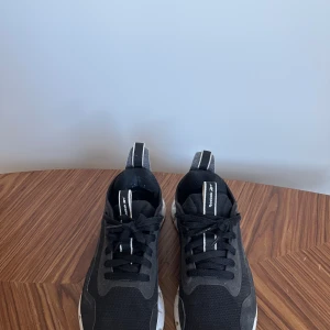 Svarta sneakers från Reebok - Snygga svarta sneakers från Reebok med vit sula och snörning. Perfekta för en sportig look eller vardagsbruk. De har en modern design med bekväm passform. Storlek 38